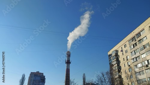 White smoke comes out of the chimney a boiler house in winter
