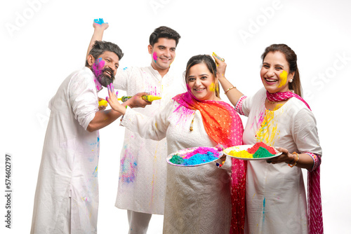 Young indian people celebrating holi festival on white background.