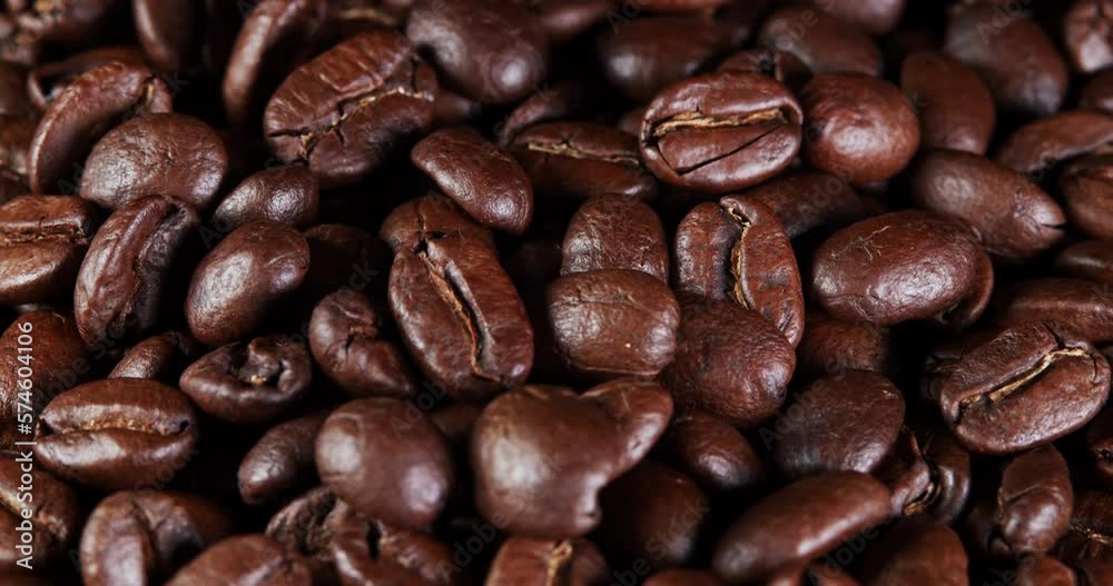 Roasted coffee beans dolly shot. Aromatic coffee beans move slowly. Slide slow motion close-up of whole roasted coffee beans. Roasted coffee beans dolly shot. Aromatic coffee beans move slowly. Slide slow motion close-up of whole roasted coffee beans.