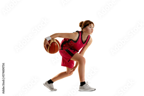 Concentration. Teen girl, basketball player in motion with ball, dribbling isolated over white studio background. Concept of sportive lifestyle, active hobby, health, endurance, competition © master1305