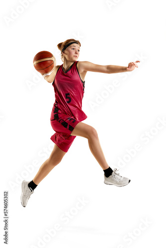 Teen girl, professional female basketball player in motion, throwing ball in jump isolated over white studio background. Concept of sportive lifestyle, active hobby, health, endurance, competition