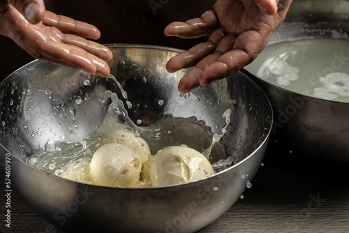 Cheesemaker, showing freshly made mozzarella. The homemade cheese maker produces caciocavallo. Pasta filata, Traditional Italian mozzarella