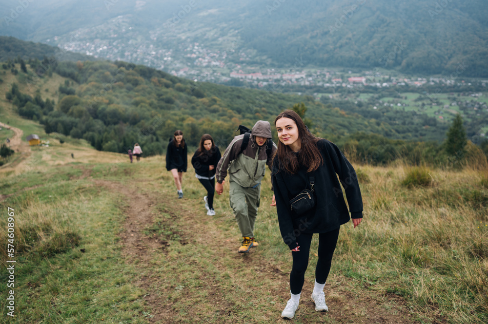 Tourist friends climb the mountains together. Hiking in the mountains with a group on a path against the background of a beautiful landscape. Tourist friends climb the mountains together. Hiking in the mountains with a group on a path against the background of a beautiful landscape.
