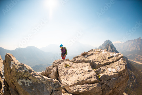 hiking in the mountains. a girl with a backpack walks along a mountain range. climbing and hiking.