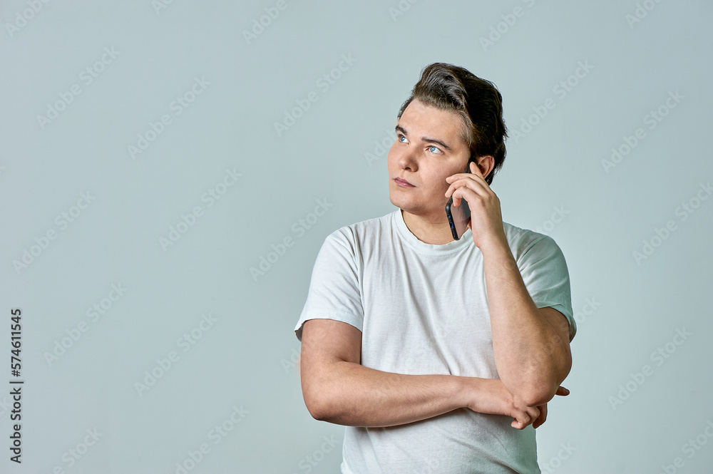 a man on a gray background is talking on the phone a man on a gray background is talking on the phone