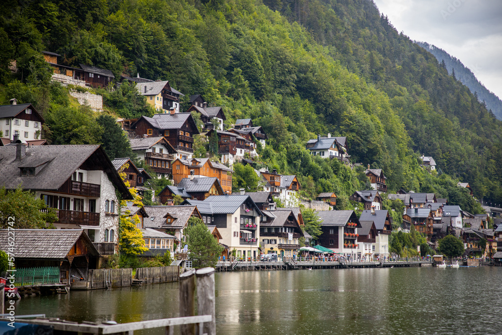 old austrian mountain village on mountain slope with lake and reflection