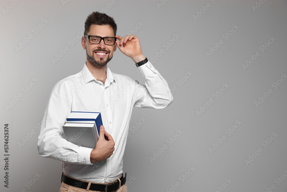 Happy teacher with glasses and books against beige background. Space for text Happy teacher with glasses and books against beige background. Space for text