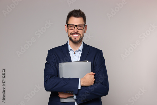 Happy teacher with glasses and stationery against beige background