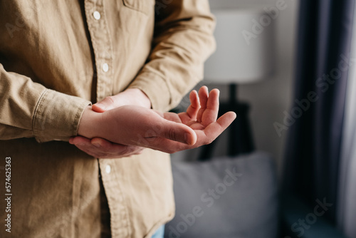 Rheumatoid arthritis concept. Close up of male suffer from numbing pain in hand, numbness fingertip, arthritis inflammation, peripheral neuropathies, unrecognizable man massage hand with wrist pain