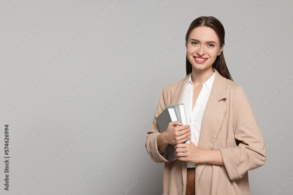 Portrait of beautiful young teacher on grey background. Space for text
