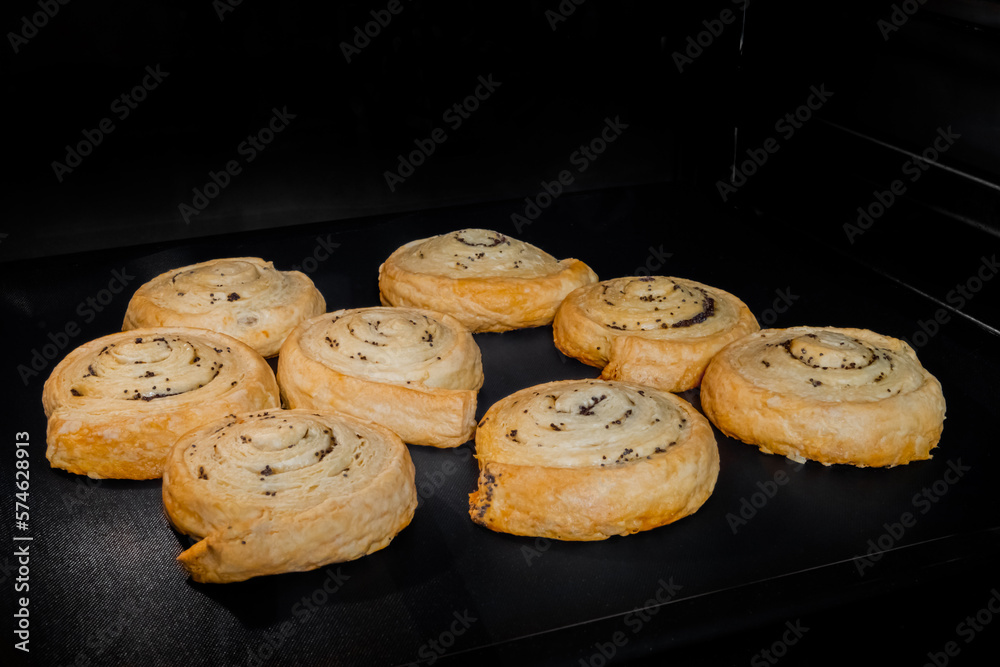 Eight baked buns with poppy seeds on tray in electric oven. Homemade bakery, food, cooking and pastry concept