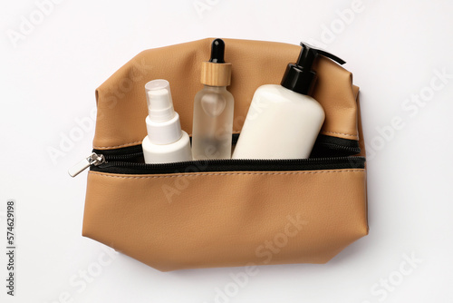 Preparation for spa. Compact toiletry bag with cosmetic products on white background, top view