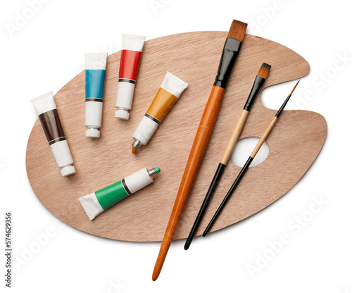 Wooden palette with oil paints and brushes on white background, top view