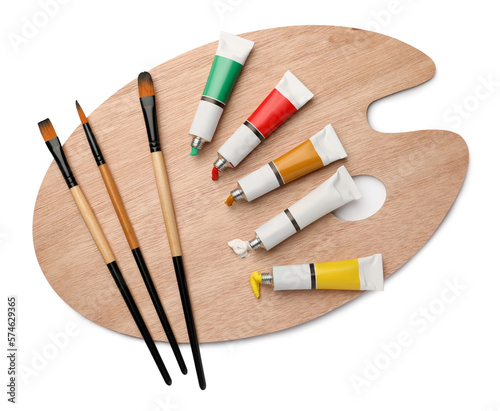 Wooden palette with oil paints and brushes on white background, top view