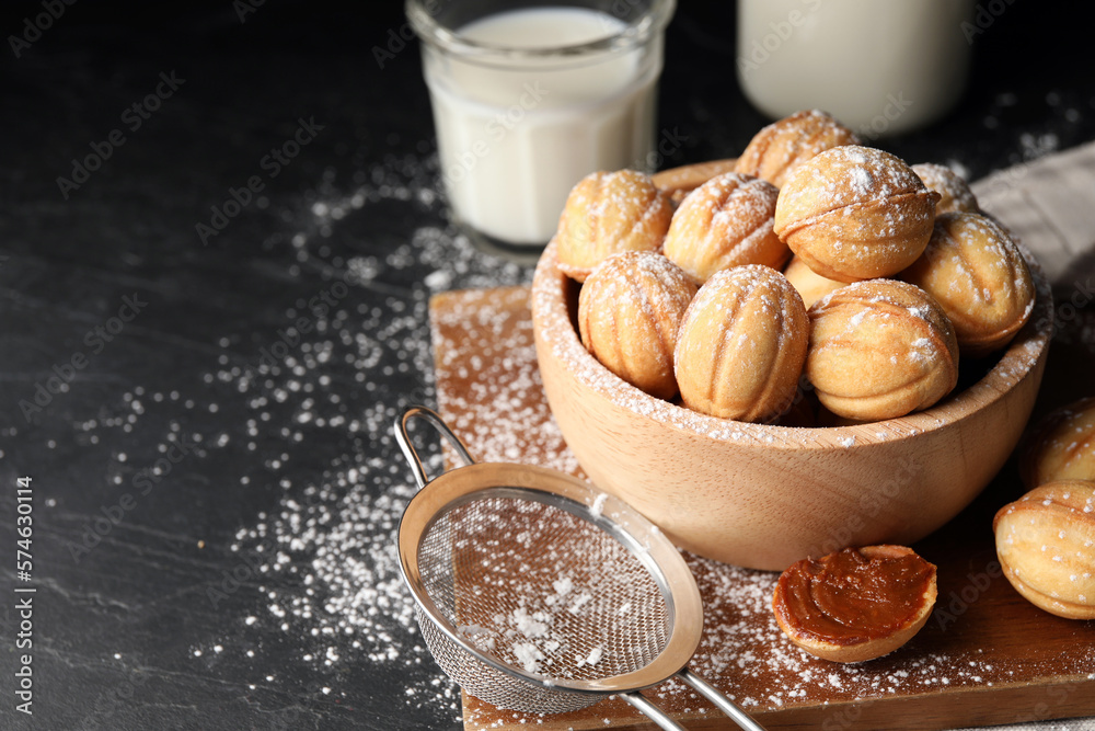 Homemade walnut shaped cookies with boiled condensed milk on black table, space for text Homemade walnut shaped cookies with boiled condensed milk on black table, space for text