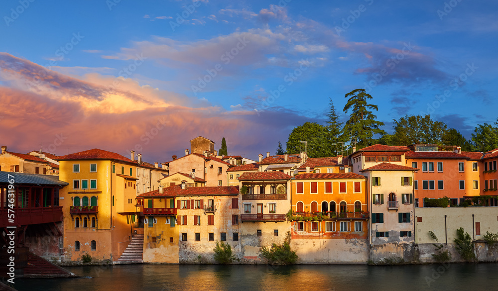 Bassano Del Grappa, Veneto Region, Italy. Ancient italian houses on river Brenta. Panoramic view at old town with vintage buildings of scenic sunset landscape