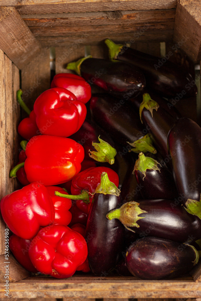 red peppers and eggplants in wooden box, healthy organic food, vitamins
