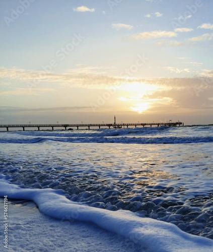 Fototapeta Naklejka Na Ścianę i Meble -  winter sunset over the baltic sea with a seabridge on the background
