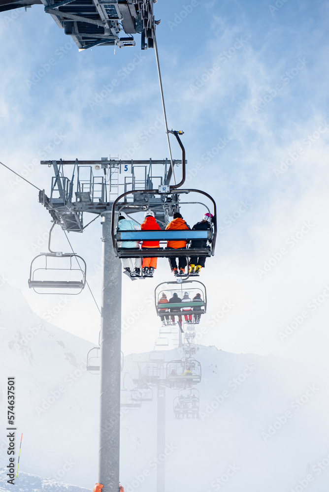 Skiing Getaway: Unrecognizable Group of Four on a Chairlift to the Slopes Skiing Getaway: Unrecognizable Group of Four on a Chairlift to the Slopes