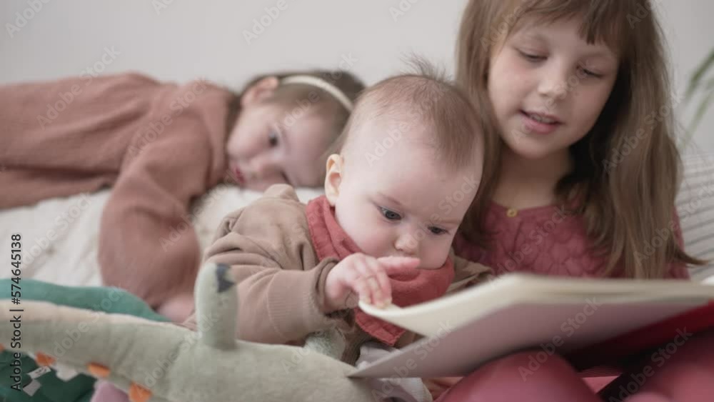 Three Little Girls Read a Book Together and Hug. Three Little Girls Read a Book Together and Hug.