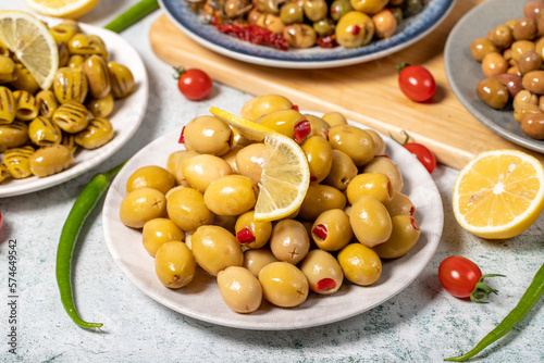Olive varieties. Assortment of black and green olives on plate on gray background