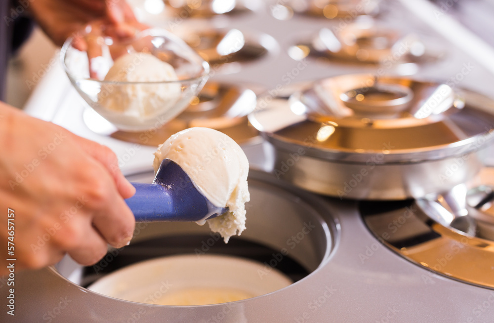 scoop of creamy ice cream in spoon from the refrigerator container