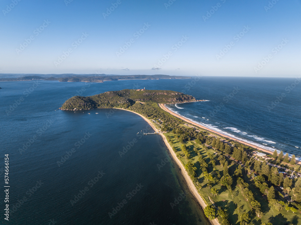 High angle aerial evening drone view of Palm Beach and Barrenjoey Head and Lighthouse. Palm Beach is an affluent beachside suburb in the Northern Beaches region of Sydney, New South Wales, Australia.