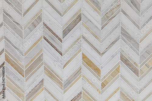 White, gray and brown marble herrinbone tile on a bathroom wall or kitchen backsplash