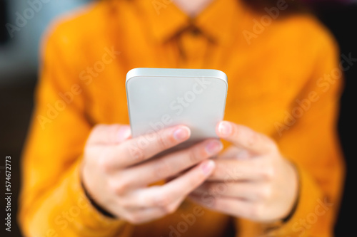 Close up, hands using phone online at home or at work in the office, rest break. Modern man in bright shirt, hipster woman