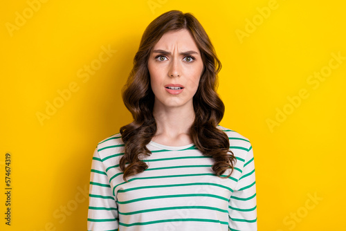 Portrait photo of funny grimace impressed nervous manager lady wavy brown hair dissatisfied hesitant face isolated on yellow color background
