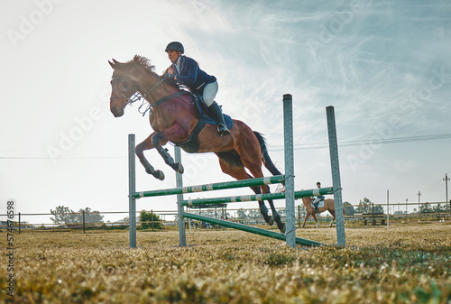 Training, competition and woman on a horse for sports, an event or show on a field in Norway. Jump, action and girl doing a horseback riding course during a jockey race, hobby or sport in nature