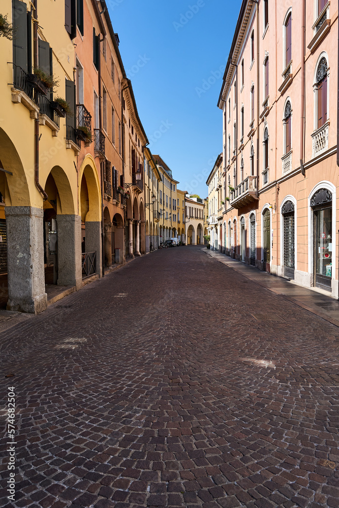 cobbled street with historic tenement houses with shadows in the city of Padua