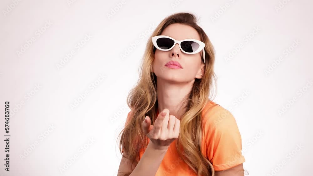 Young woman shows invite gesture, nodding say You. Positive confidence smiling pretty blonde girl, joyful happy emotion. Studio shot stylish lady in sunglasses isolated on white background. Young woman shows invite gesture, nodding say You. Positive confidence smiling pretty blonde girl, joyful happy emotion. Studio shot stylish lady in sunglasses isolated on white background.