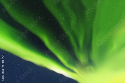 Green aurora borealis. Dark night starry sky and Northern lights