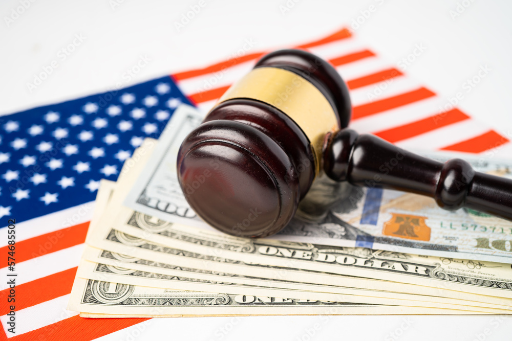 Gavel for judge lawyer and US dollar banknotes on USA America flag, finance concept.