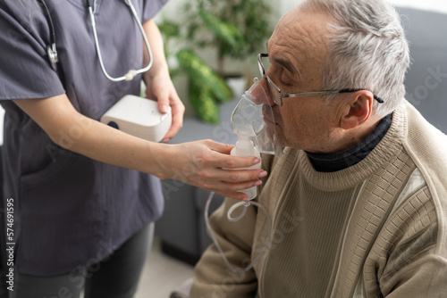 Sick elderly man makes inhalation.