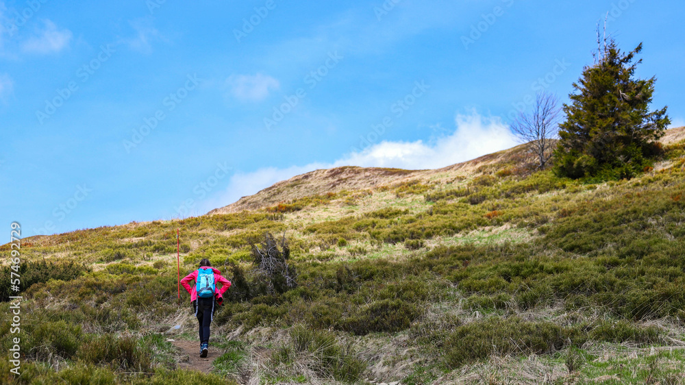 Backpacker girl enjoys a hike during spring in the Bieszczady Mountains, Poland, Europe