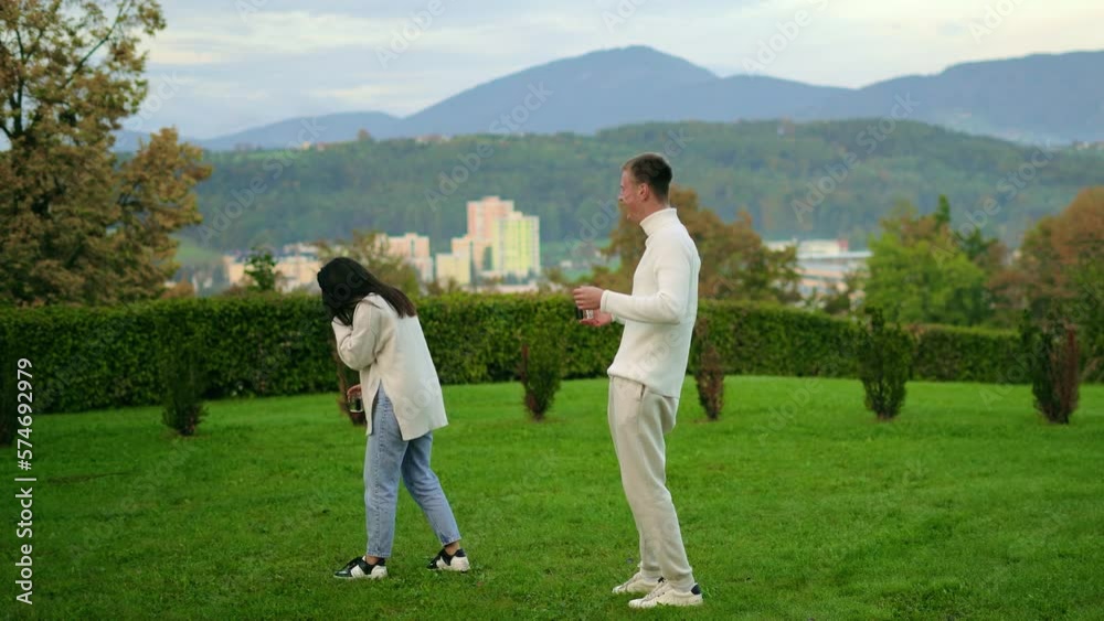 Young People Couple Stay Communicate, drink tea, mountains background, white clothes Young People Couple Stay Communicate, drink tea, mountains background, white clothes