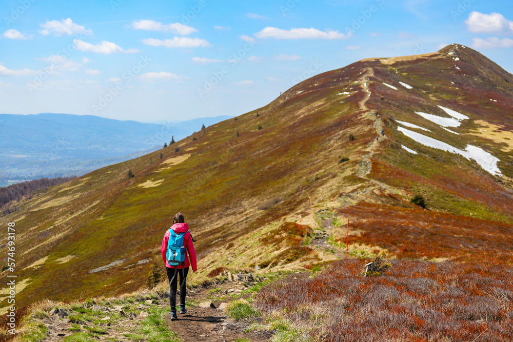 Backpacker girl enjoys a hike during spring in the Bieszczady Mountains, Poland, Europe