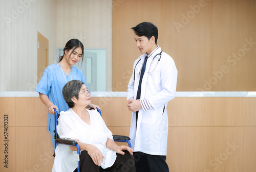 Patient elderly woman in wheelchair care by nurse listen doctor about health care and medicine at hospital.