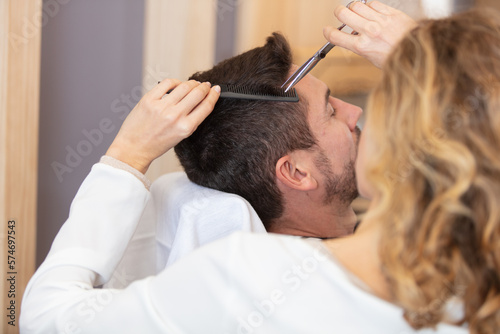 pretty woman working as a hairdresser and cutting hair