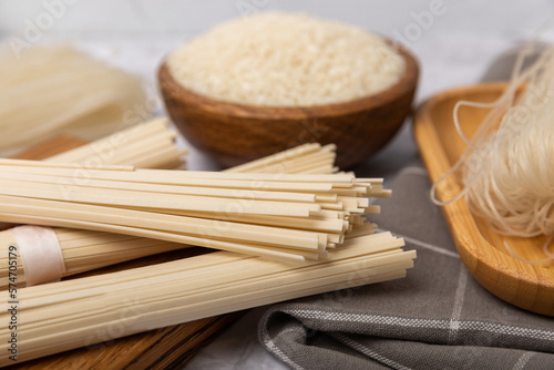 Dried raw rice noodles and rice on a light texture background.Noodles with rice flour. Funchoza. Diet food. Healthy food. Place for text. Place for copying.