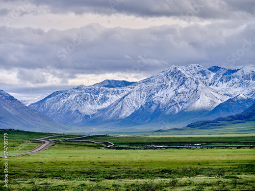 Beautiful rugged and snow-covered Mountain peaks of the Brooks Range in Alaska between the Coldfoot Camp and Prudhoe Bay with the Alaska Oil Pipeline traversing the treeless Tundra