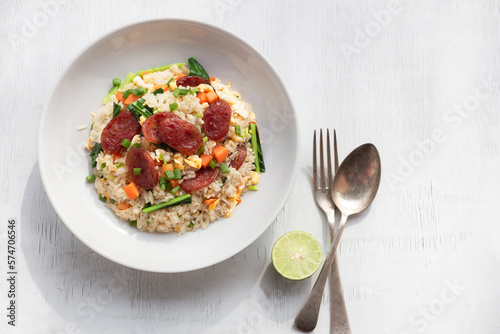 Chinese sausage fried rice on white wood table.
