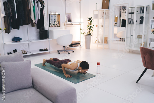 Slim woman doing yoga in spacious living room