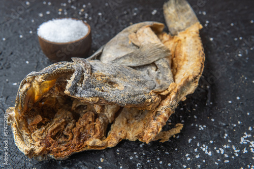 close-up of the head of a dried cod preserved with salt on a black background