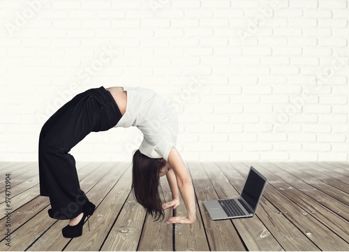 Happy young businesswoman in yoga positions work on computer.