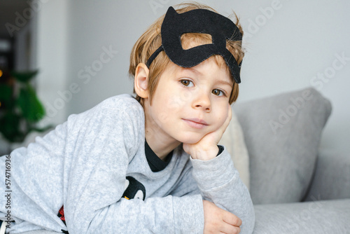 Little Boy with carnival costume . Costume of bat lying on sofa. photo