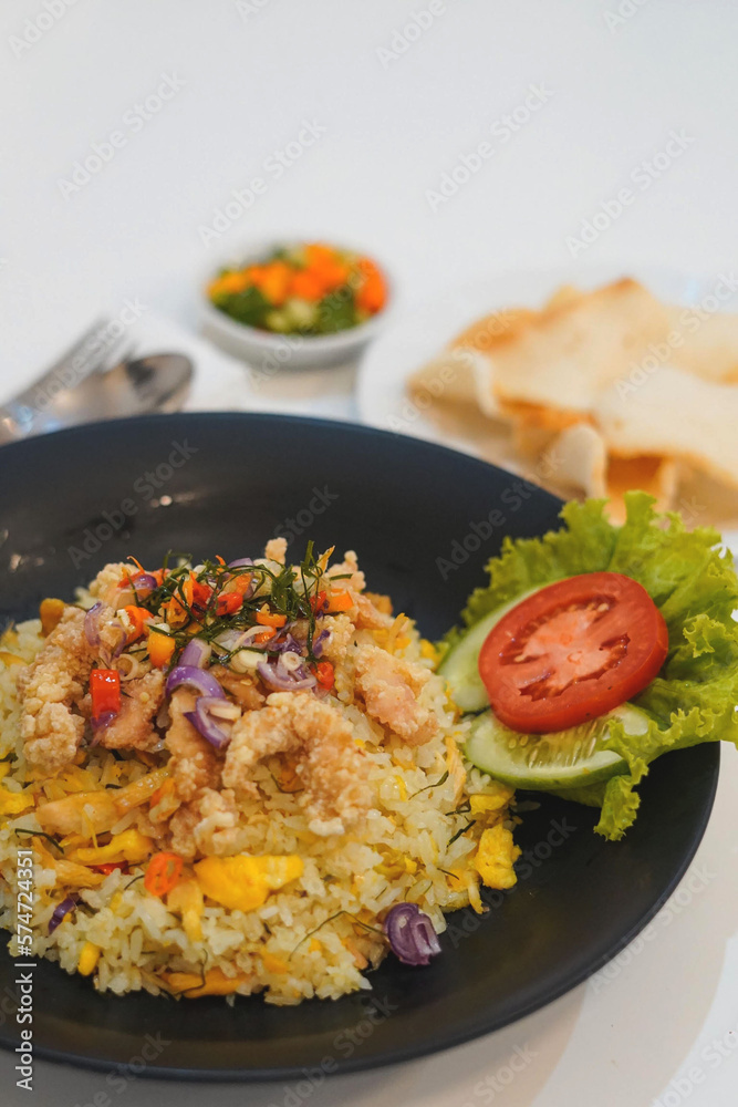 Nasi Goreng Gourmet. Indonesian staple dish of fried rice, served luxuriously with betutu chicken, shrimp crackers, pickles and chili sauce. Nasi Goreng Gourmet. Indonesian staple dish of fried rice, served luxuriously with betutu chicken, shrimp crackers, pickles and chili sauce.