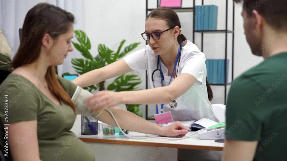 The doctor puts a pressure measuring device on the pajette's arm. The doctor puts a pressure measuring device on the pajette's arm.